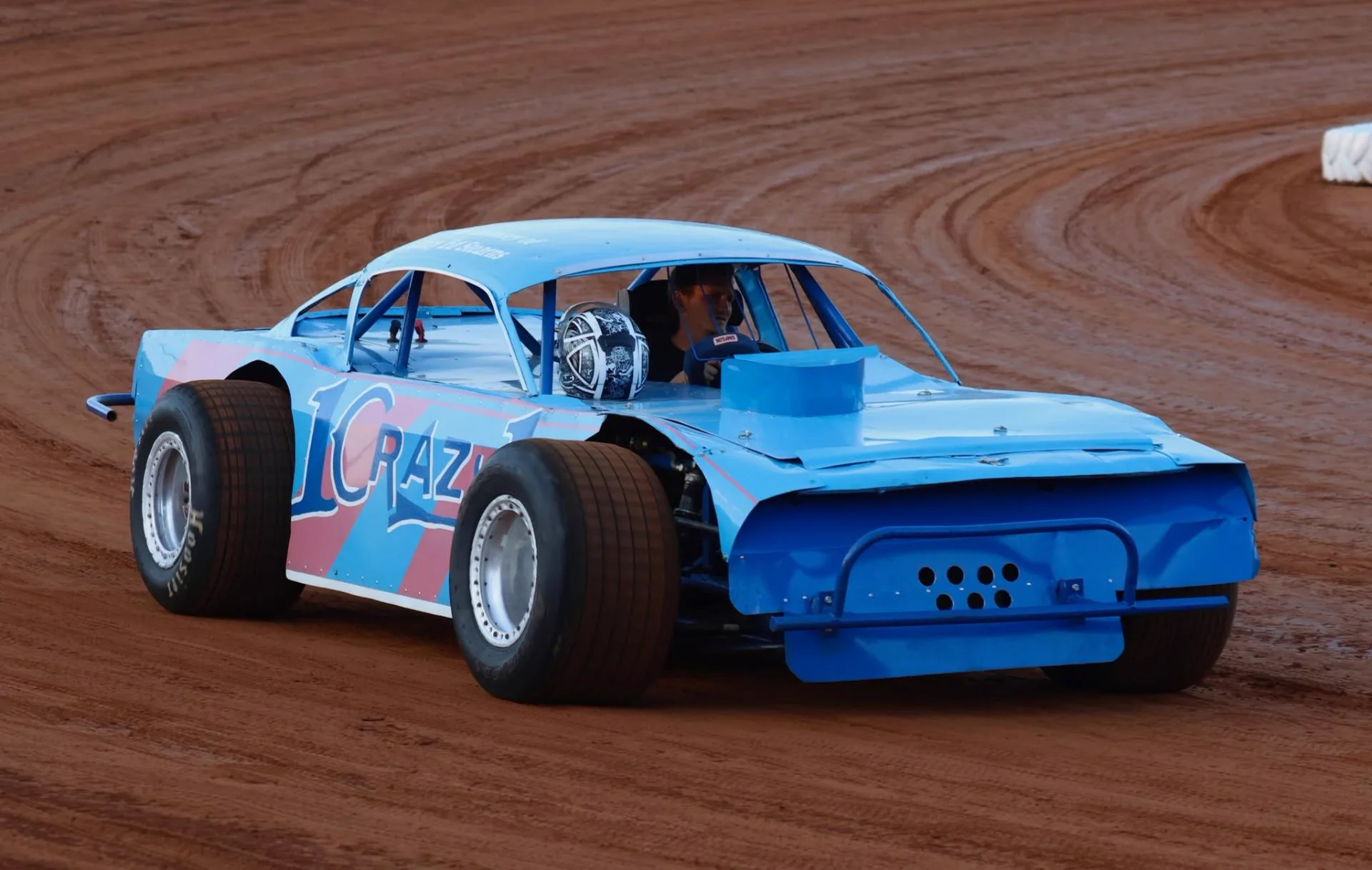 Blue 'Crazy' #1 vintage stock car on a clay track